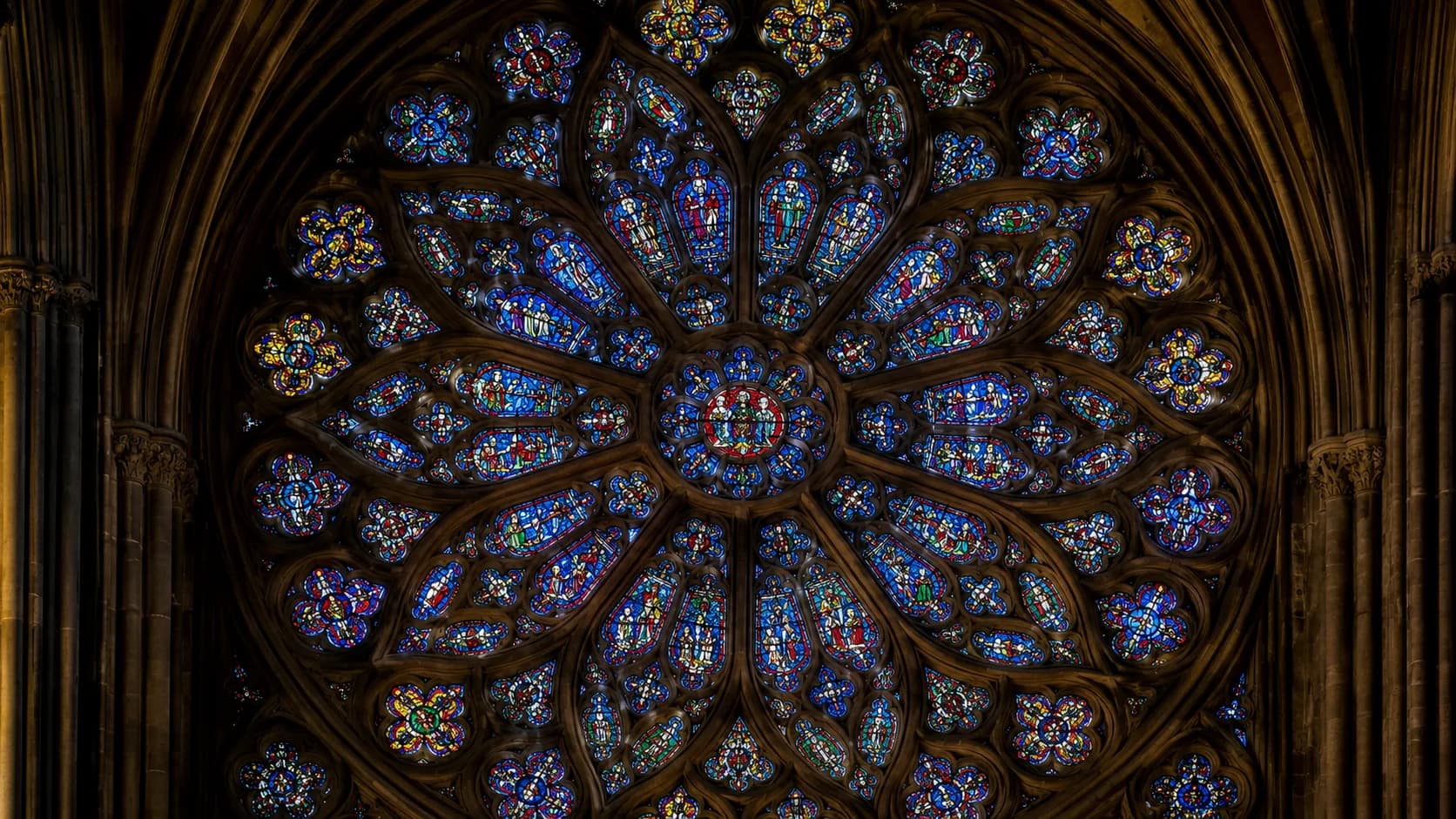 Historic stained glass rose window preservation detail in deep blue tones